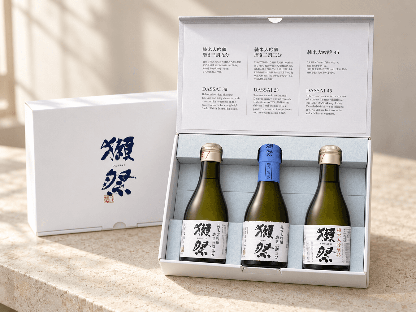 An open Dassai gift box holding three 180ml Junmai Daiginjo bottles